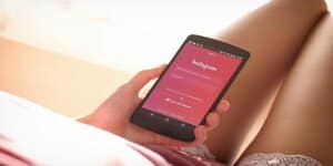 emand houdt een smartphone vast met het Instagram-login scherm zichtbaar, wat de eerste stap kan zijn bij het proces om de Instagram bio link aan te passen.
