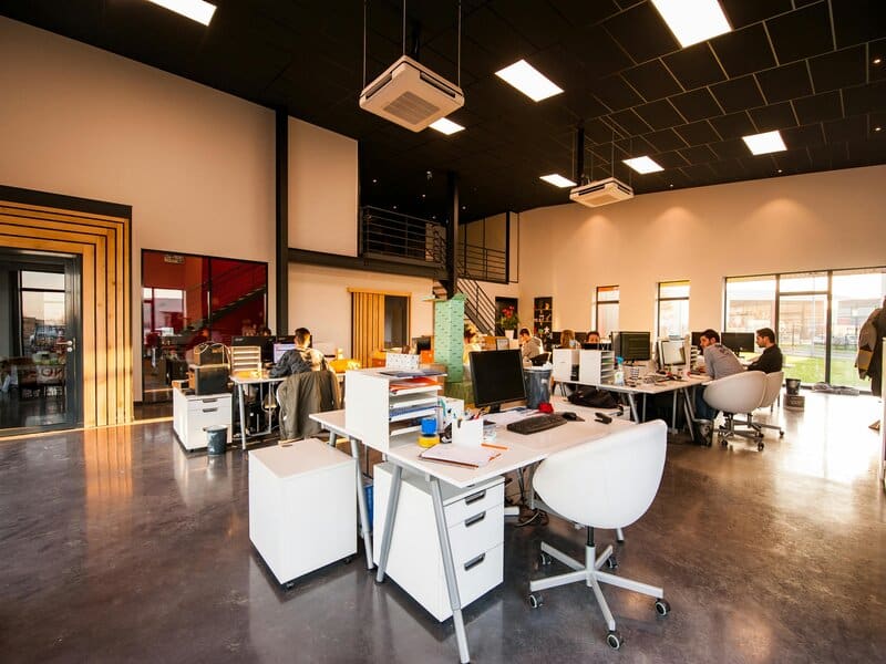 Foto van een open kantoorruimte met diverse werkstations en computers, wat een sociale media werkplek kan voorstellen en de voordelen van een social media agency illustreert.